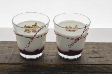 Layered dessert with fruits yogurt and cream cheese in glass jar
