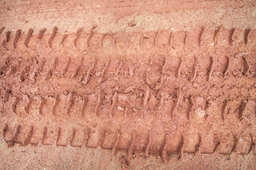 Tire tracks on a muddy road in the countryside.