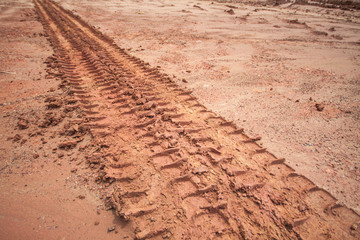 Tire tracks on a muddy road in the countryside.