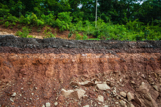 Section of asphalt road collapses.Layer of soil beneath section