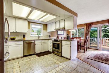 White kitchen room with cozy dining area and walkout deck