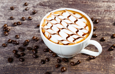 Cup of coffee and roasted bean on old wooden table