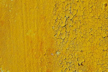 Yellow cracked paint on rusty background