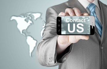 business man hand holding smartphone with the message contact us
