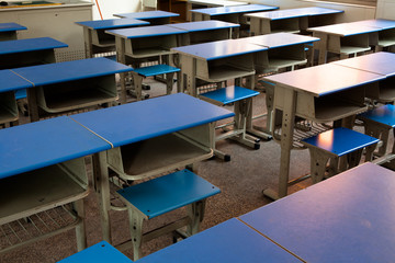 Fototapeta na wymiar Empty classroom with chairs, desks and chalkboard.