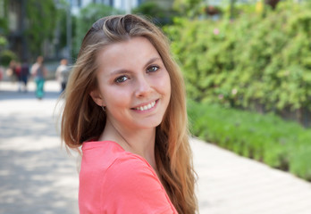 Junge Frau im roten Shirt lacht in die Kamera
