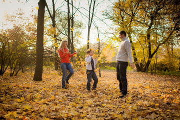 Fototapeta premium wonderful parents and son in an autumn garden. yellow autumn lea