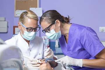 female dentist working with her assistant - 70824883