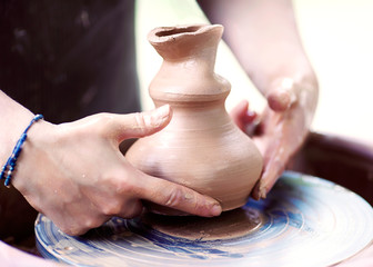 Hands working on pottery wheel