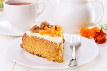 Carrot cake with icing on white plate