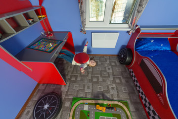 little girl in children room under chair at inverted house