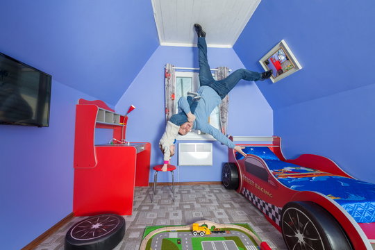 Father With Daughter In Children Room At Inverted House