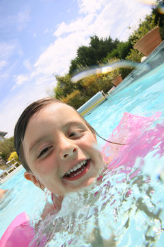 Portrait of cute little girl in swimming pool