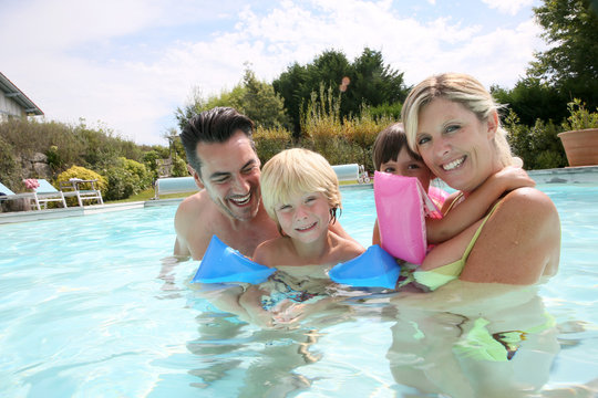 Happy family enjoying swimming time in pool