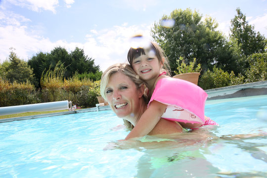 Mother and daughter playing in swimming-pool