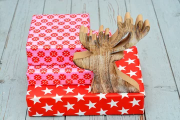 Tapeten Gekleurde rode pakjes op oud hout met rendier © trinetuzun