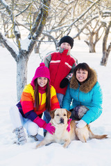 Fototapeta na wymiar family with dog in a snowy garden