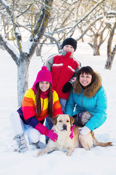 family with dog in a snowy garden