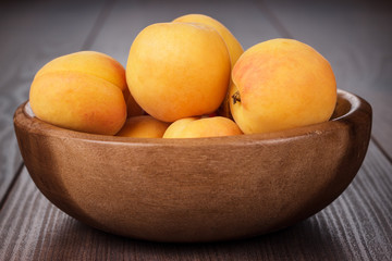 wooden bowl some fresh apricots on the table