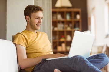 Young man using laptop on his couch