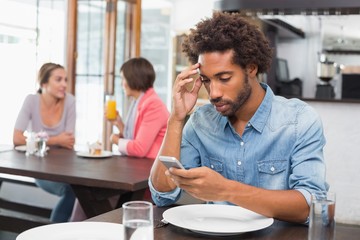 Handsome man sending a text