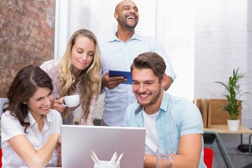 Business team laughing together in front of the laptop