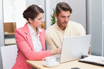Focused business people working together on laptop