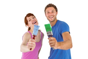 Couple both holding paint brushes