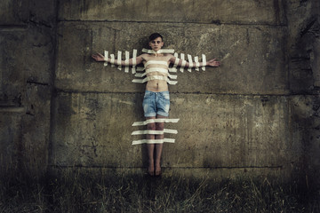 man sticked to the wall with adhesive tape