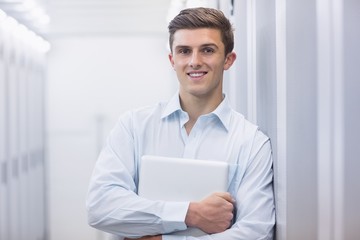 Portrait of a smiling technician holding a laptop