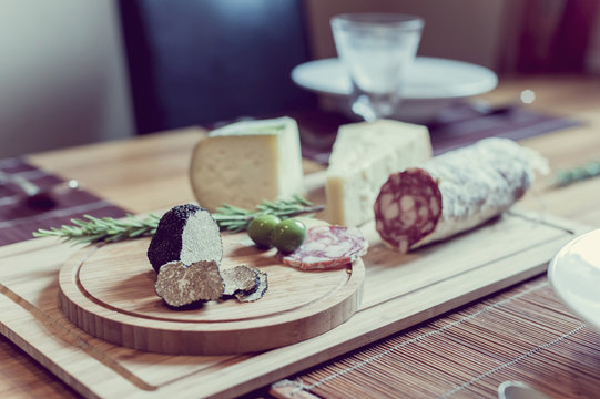 Wooden plate with truffles, cheese and salami