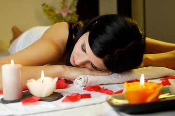 Fototapeta na wymiar Beautiful brunette model relaxing on massage table at spa salon