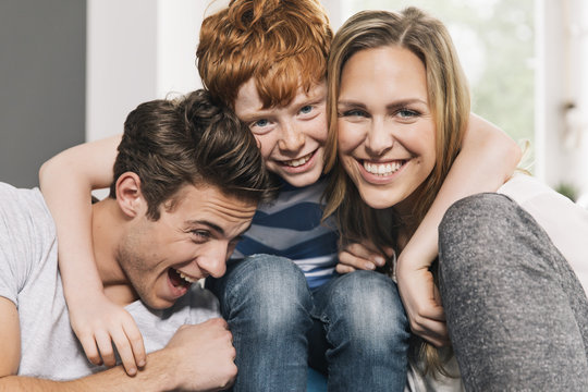 Portrait of happy young family sitting on their couch at living room