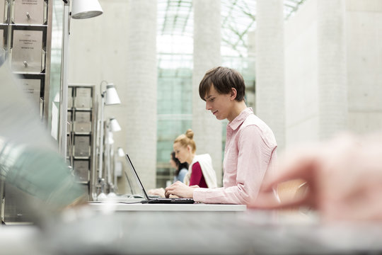 Students in a university library using laptops