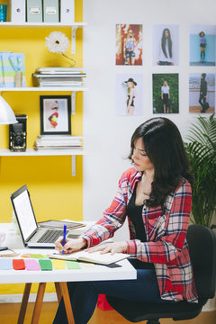 Female fashion blogger telephoning at her office