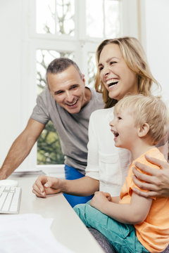 Happy grandfather, mother and son at desk