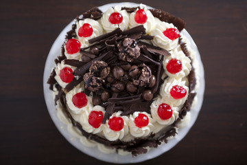 Chocolate cake with cream and cherries, from above.