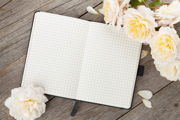Blank notepad and white rose flowers