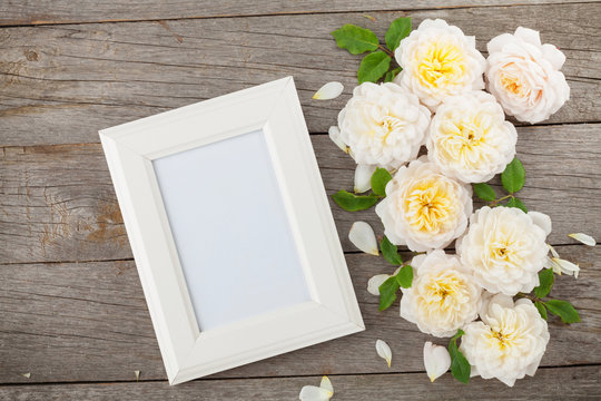 Blank photo frame and white roses