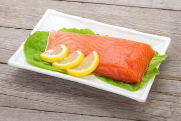 Fresh salmon fish with lemon and salad leaves