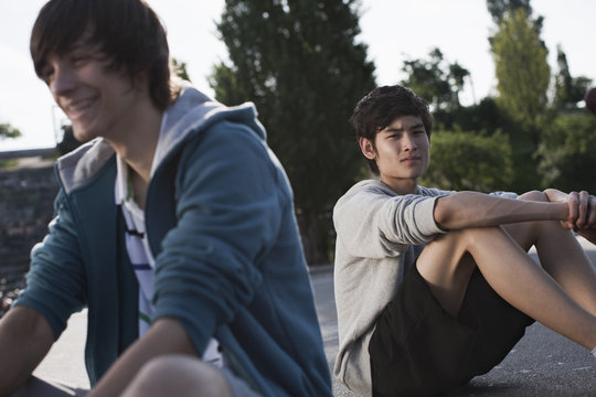 Germany, Berlin, Teenage boys sitting in playground
