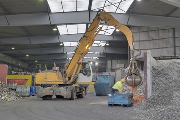 Excavator in a scrap metal recycling plant