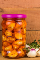 pickled garlic in a jar of green marjoram