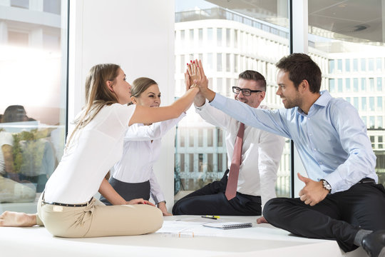 Poland, Warsaw, four successful businessmen sitting on conference table