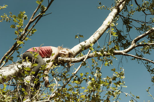 Girl lying on branch of a tree