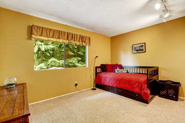 Bright yellow bedroom with black wooden bed