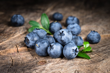Blueberry with leaves on wooden background