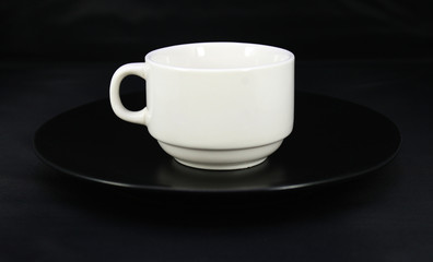 Cup and saucer on black background