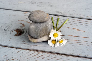Gordijnen Zen stenen  met bloemen op oud hout. © trinetuzun