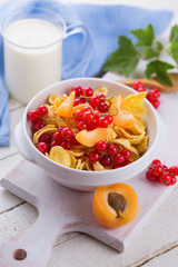 Cornflakes in bowl with red сcurrant